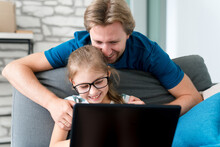 Father and daughter enjoying fast Spectrum internet together on a laptop